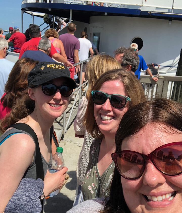Three women pose on the ferry deck for Fort Sumter in Charleston, SC