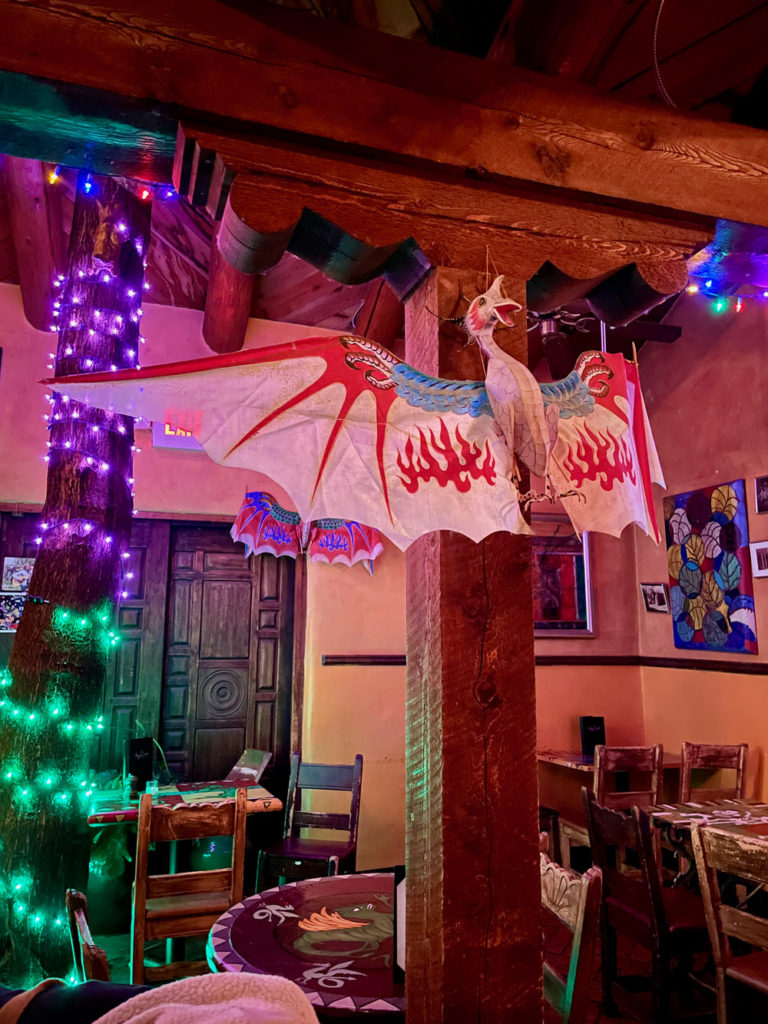 Paper dragon and purple and green Christmas lights decorate a Santa Fe bar