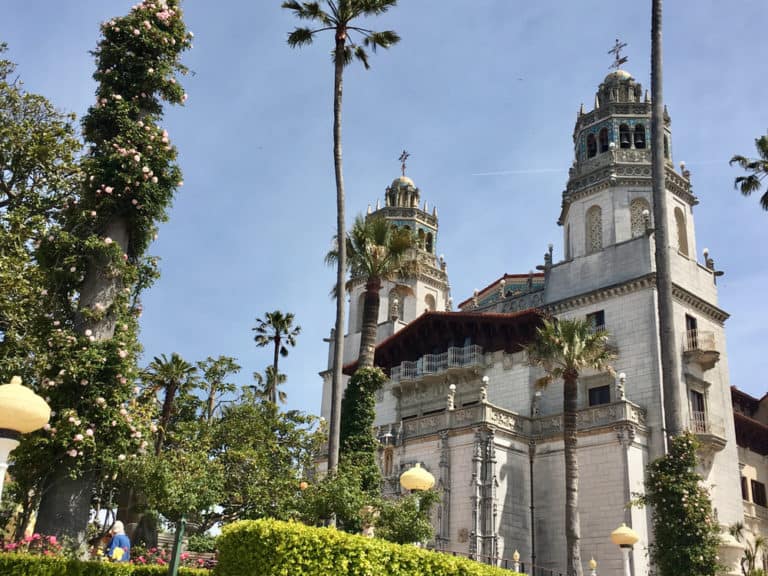 Palm trees and scrubs in front of Hearst Castle's two Islamic style turrets.