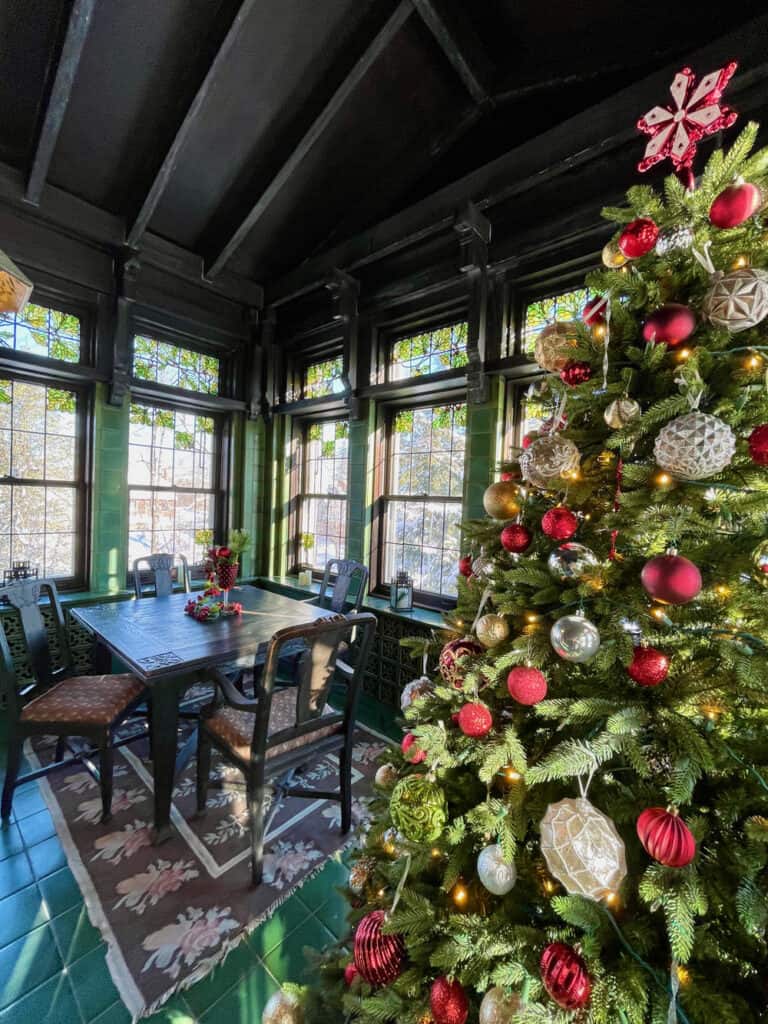 A Christmas tree in a green breakfast room