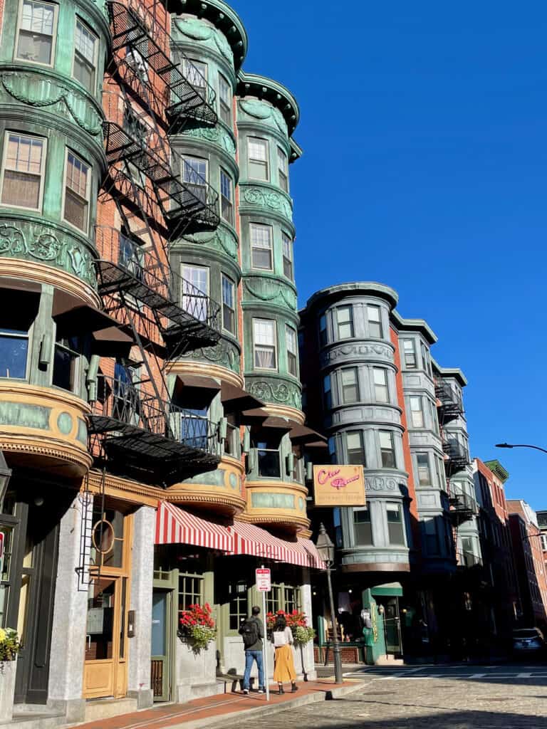 Old apartment building with exposed fire escape laters and copper balconies in Little Italy Boston