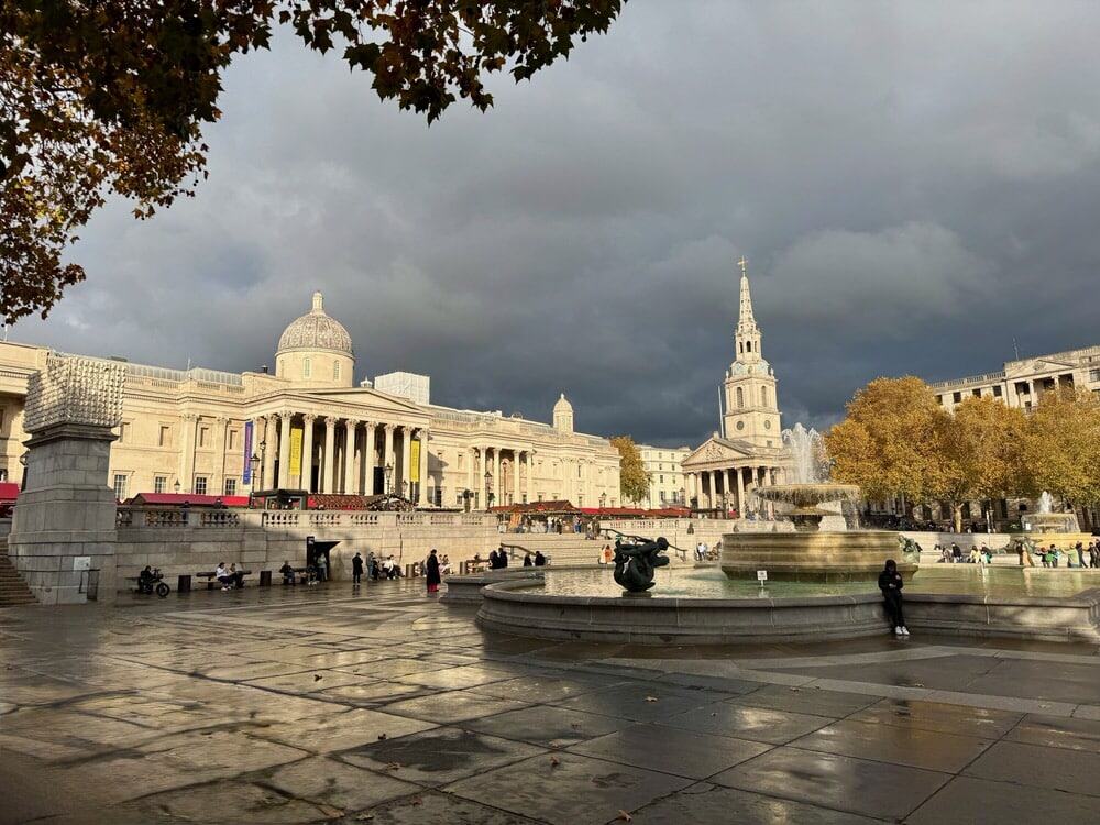 Looking across Trafalgar Square in central London at the National Gallery art museum and St. Martin-in-the-Fields church on an overcast day