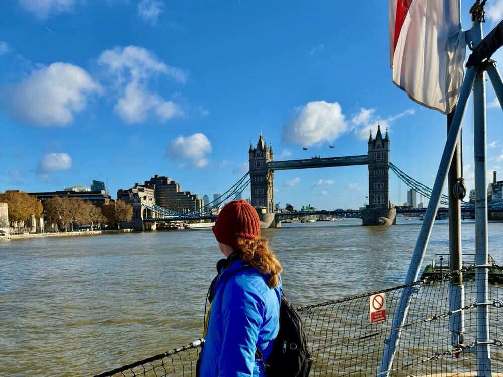 Woman looks over her shoulder at Tower Bridge on the Thames River in the City of London England