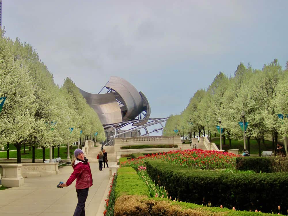Woman poses on the sidewalk leading the Millennium Park in downtown Chicago in spring