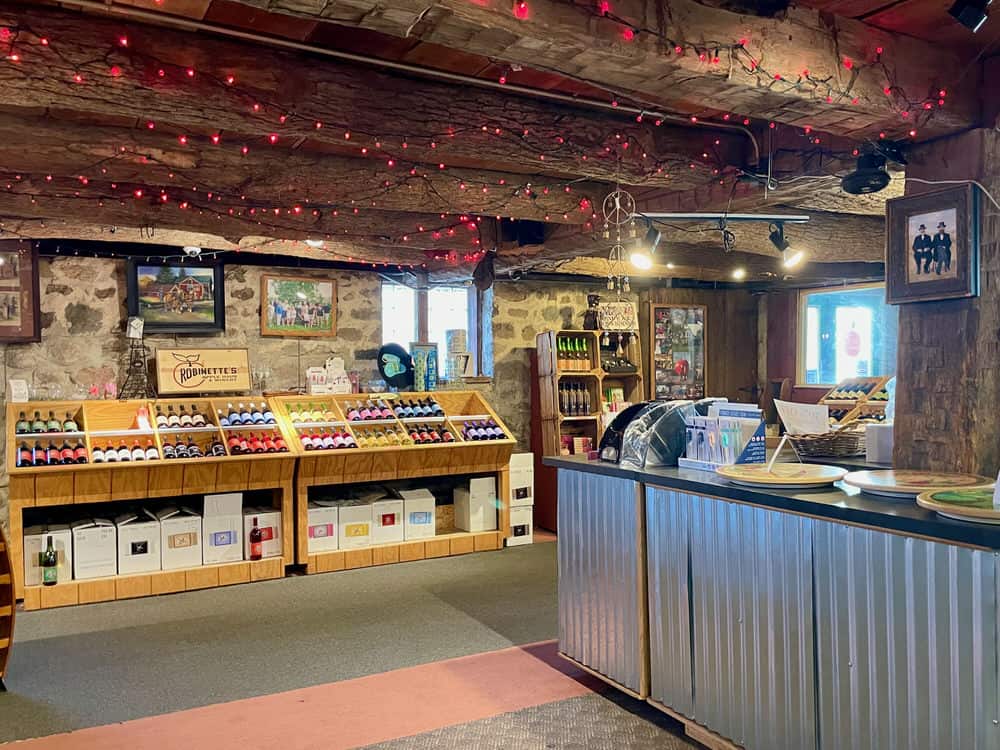 An open room with a counter and shelves filled with wine bottles.