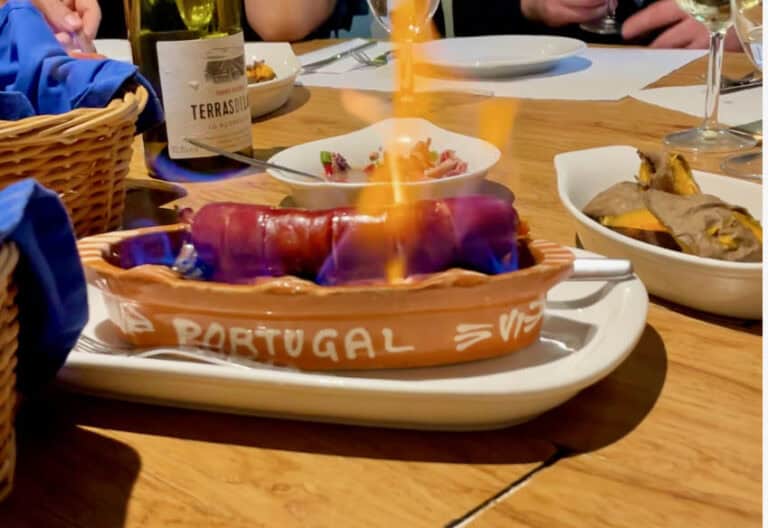 A flaming sausage in the middle of a restaurant table