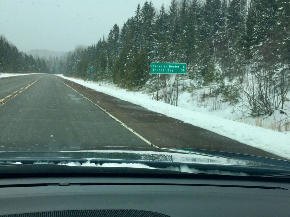 View of U.S. Highway 61 near the Canadian border as seen through a windshield in winter