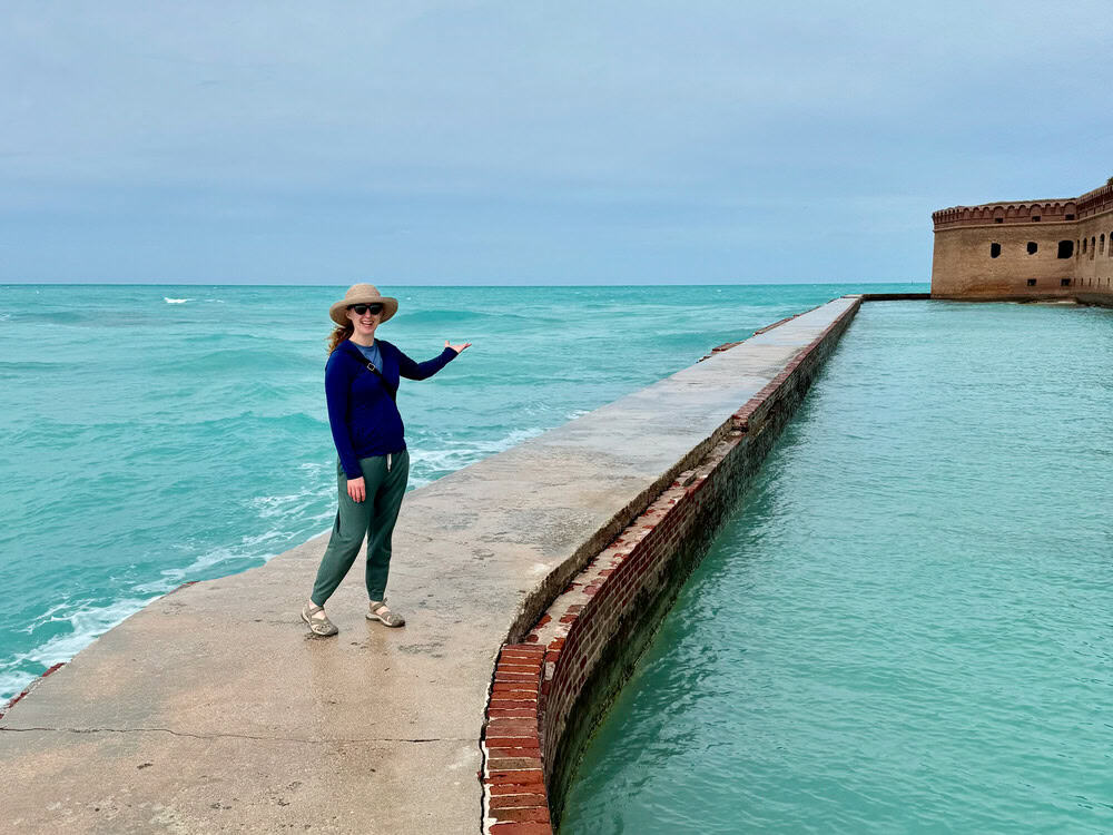 Woman poses on the moat surround Fort Jefferson at Dry Tortugas National Park