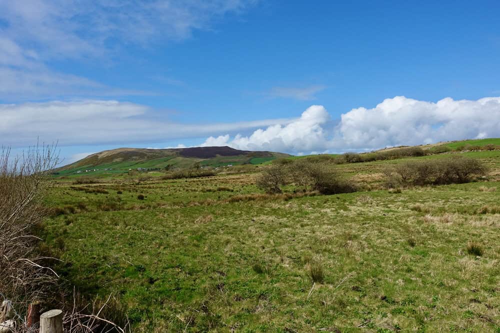 Green hillside rising out of the Irish countryside
