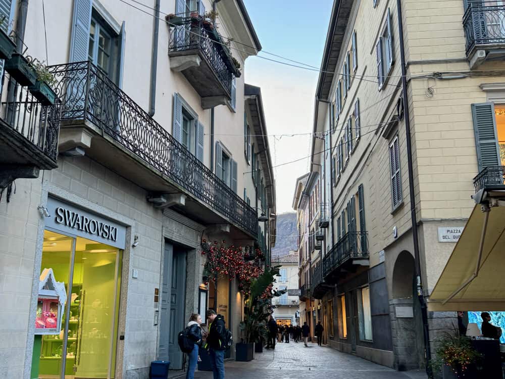 Buildings crowded over narrow cobblestone streets in Como City, Italy