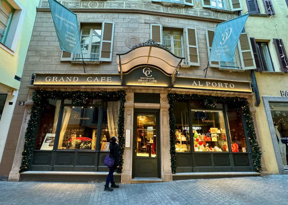 A woman looks into the large display windows of Grand Cafe Al Porto in Lugano, Switzerland's Old Town.