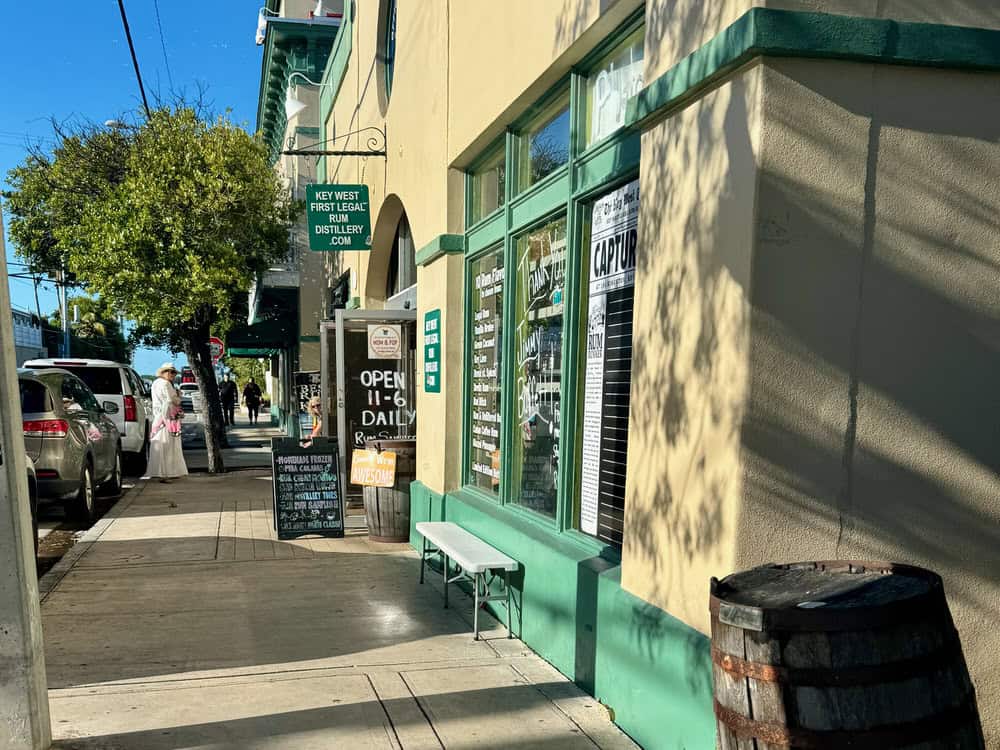 The tan and green exterior of Key West First Legal Rum Distillery.