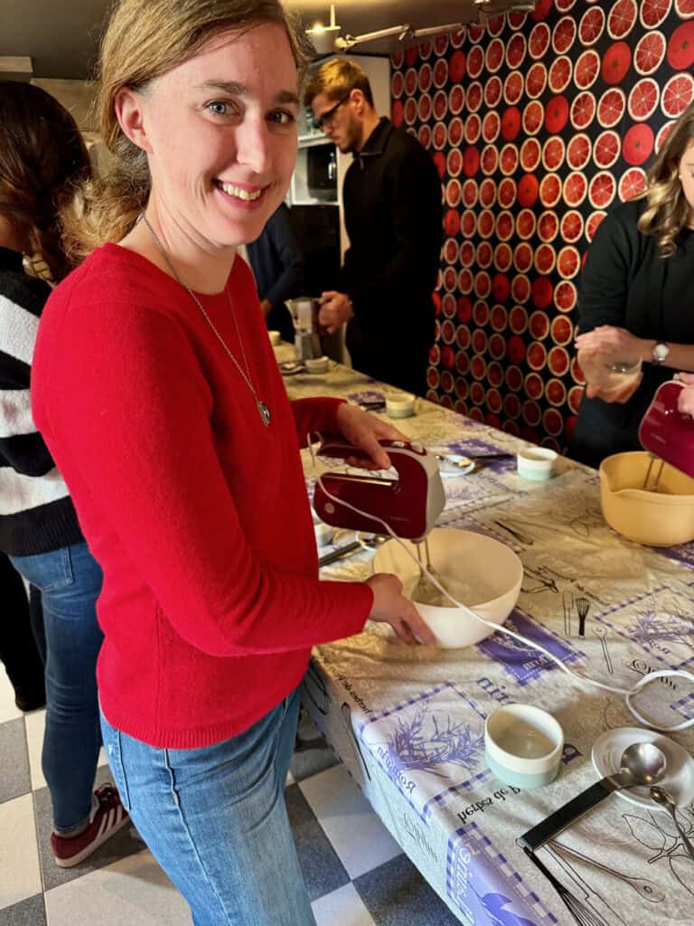 Woman beats egg whites with a hand mixer at a cooking class in Milan, Italy