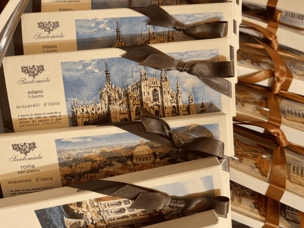 Display of souvenir chocolate bars printed with paintings of famous Italian cathedrals including Milan Duomo and Rome St. Peter's. All chocolate bars are tied with a brown ribbon.