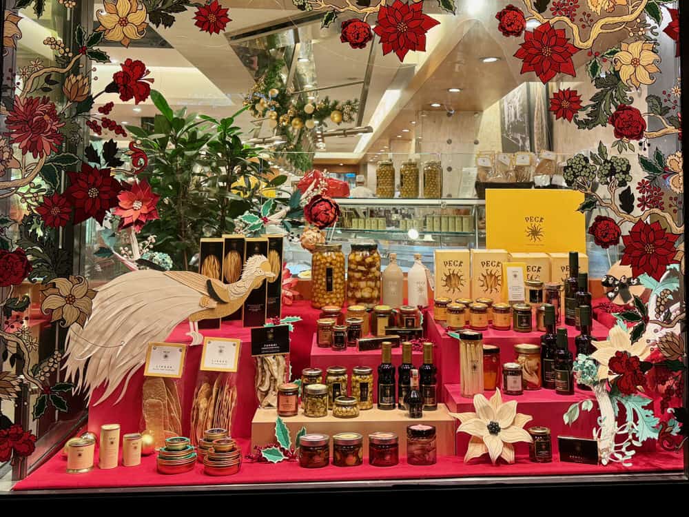 Colorful holiday window display at Peck's gourmet grocery store in Milan. Window is filled with pastas, olives, and jars.