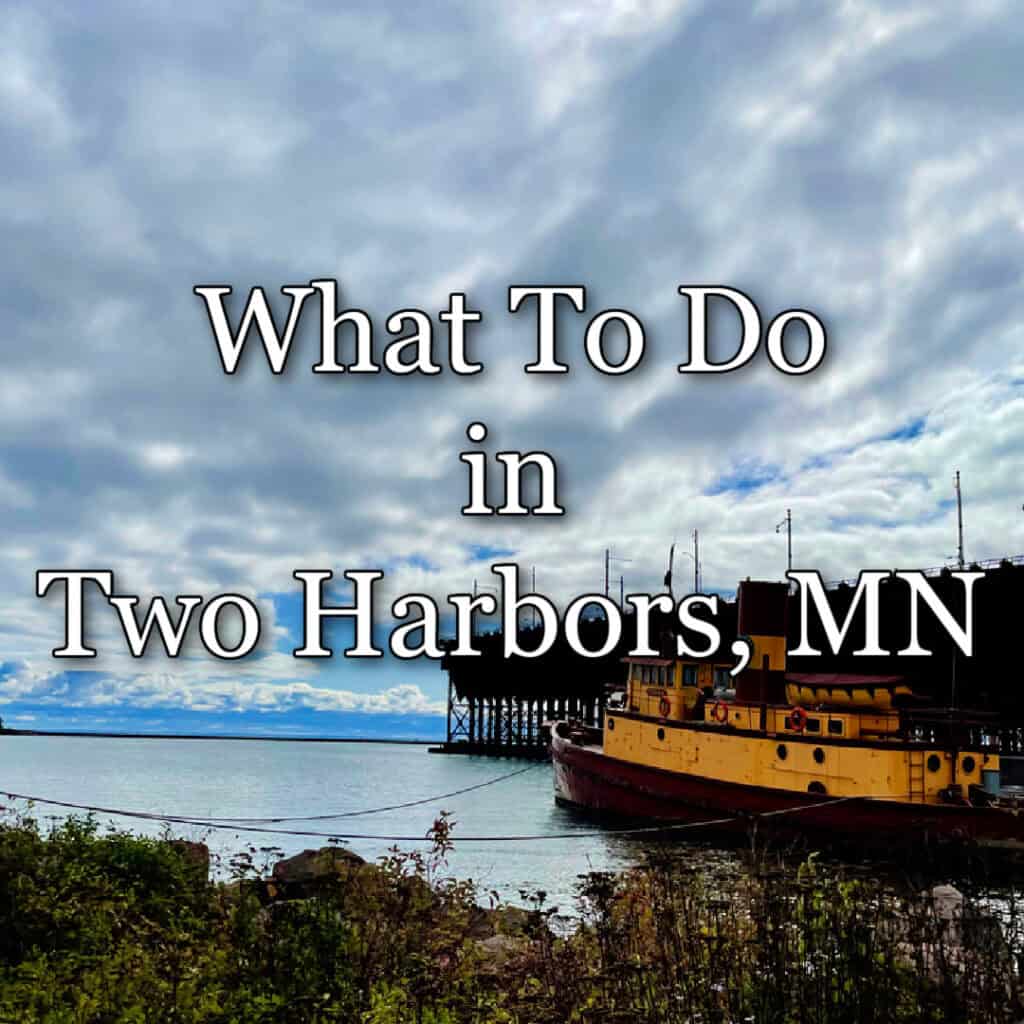 Two Harbor ore docks and Edna G tug as seen from Agate Bay Beach. Text overlay reads "What to do in Two Harbors, MN"
