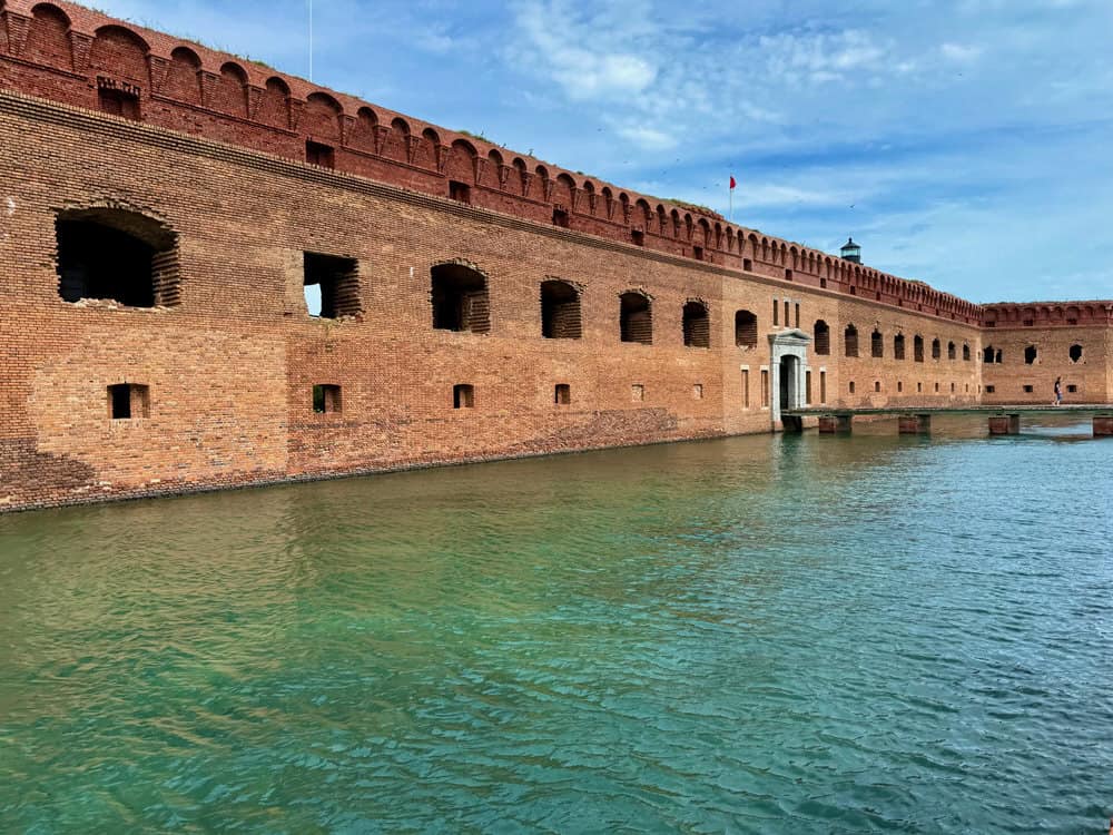 Large red brick fort with entrance and moat