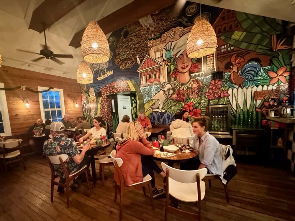 Diners sit in front of a colorful mural in a Key West cafe