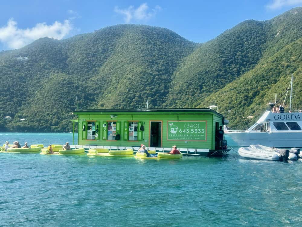A floating restaurant and bar surrounded by floaties and boats