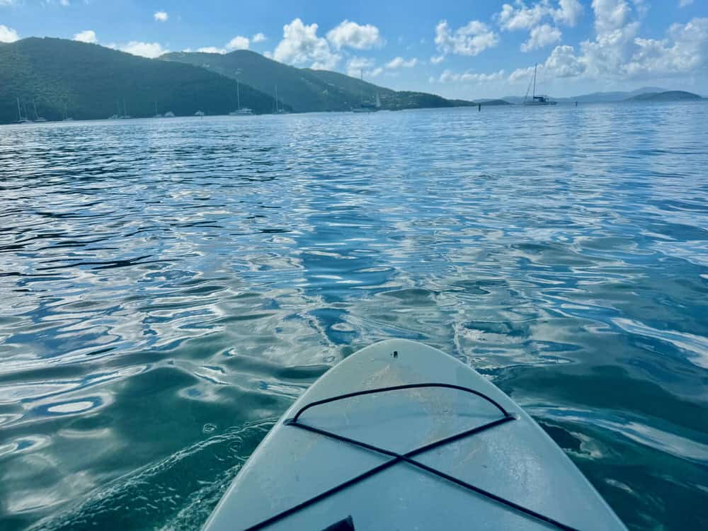 Tip of a blue paddleboard in the middle of Maho Bay on the north shore of St John USVI