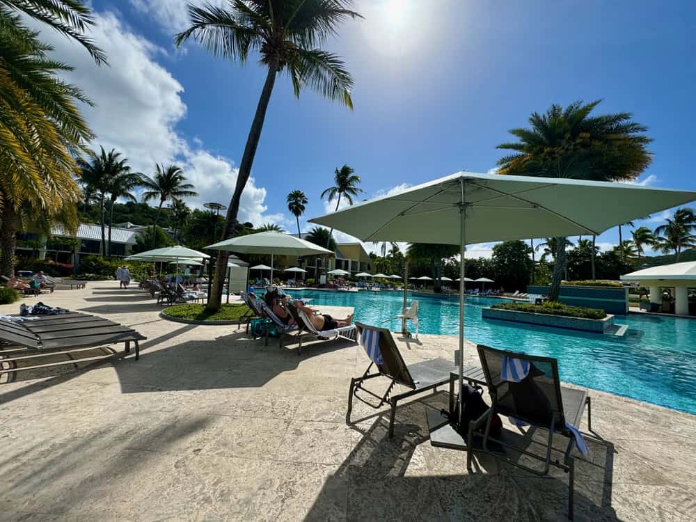 Pool chairs, umbrellas, and palm trees surround the pool at the Westin St. John.