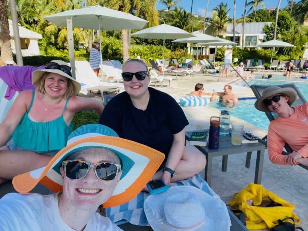 Four women lounging at a Caribbean pool