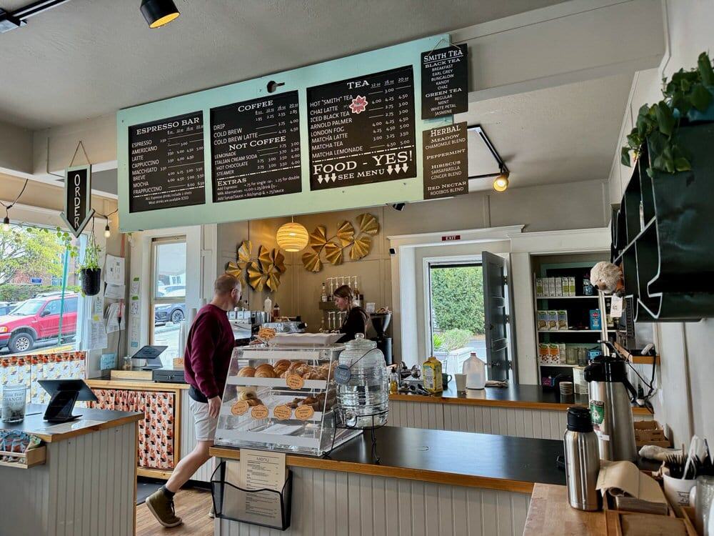 Two employees work behind the corner of a brightly lit coffee shop on San Juan Islands.