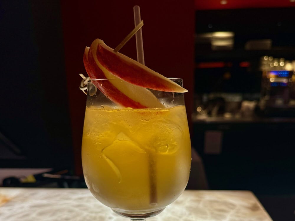 A calvados cocktail glows in a dark bar in Rouen France