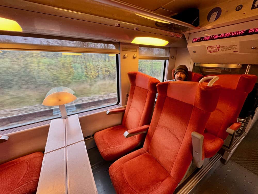 Man looks excited sitting in a train seat on a French train