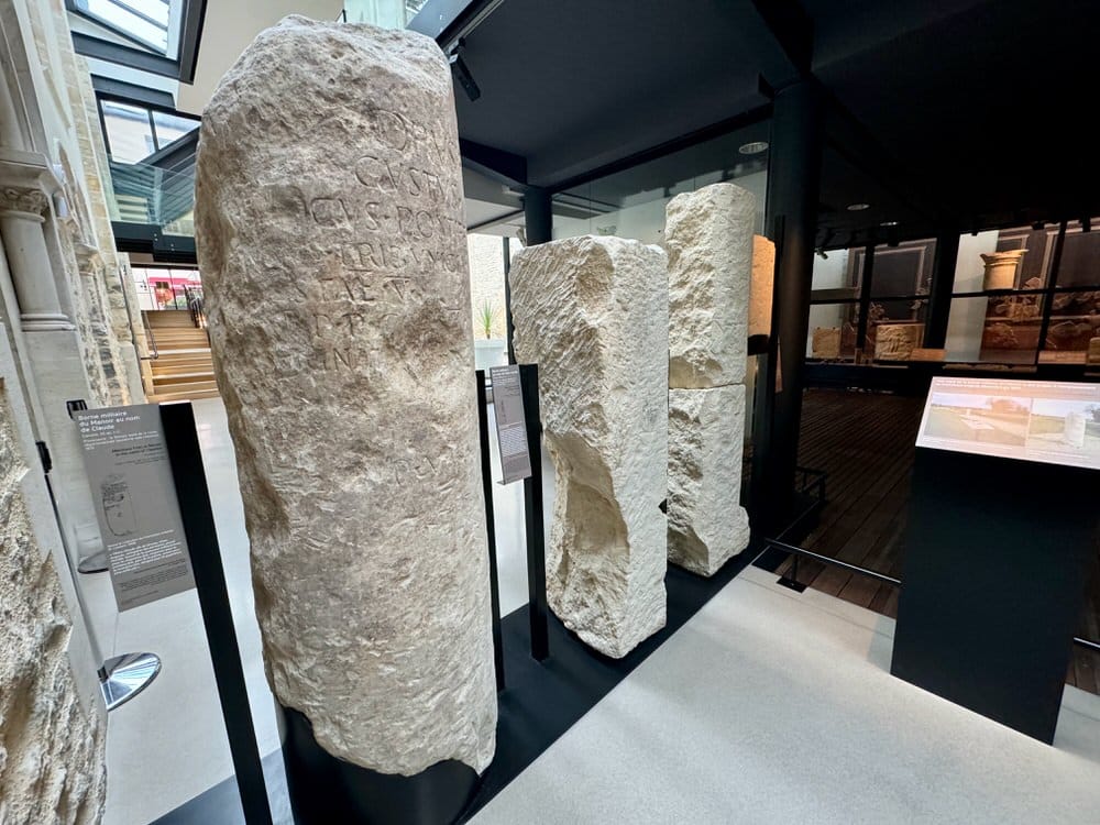 Three large stone pillars on display in a museum.