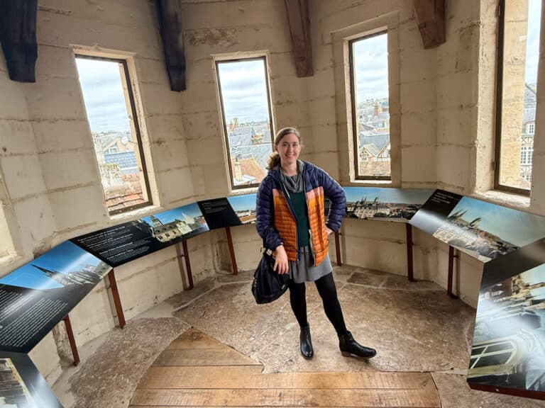 Woman stands in a circular room filled with museum panels.