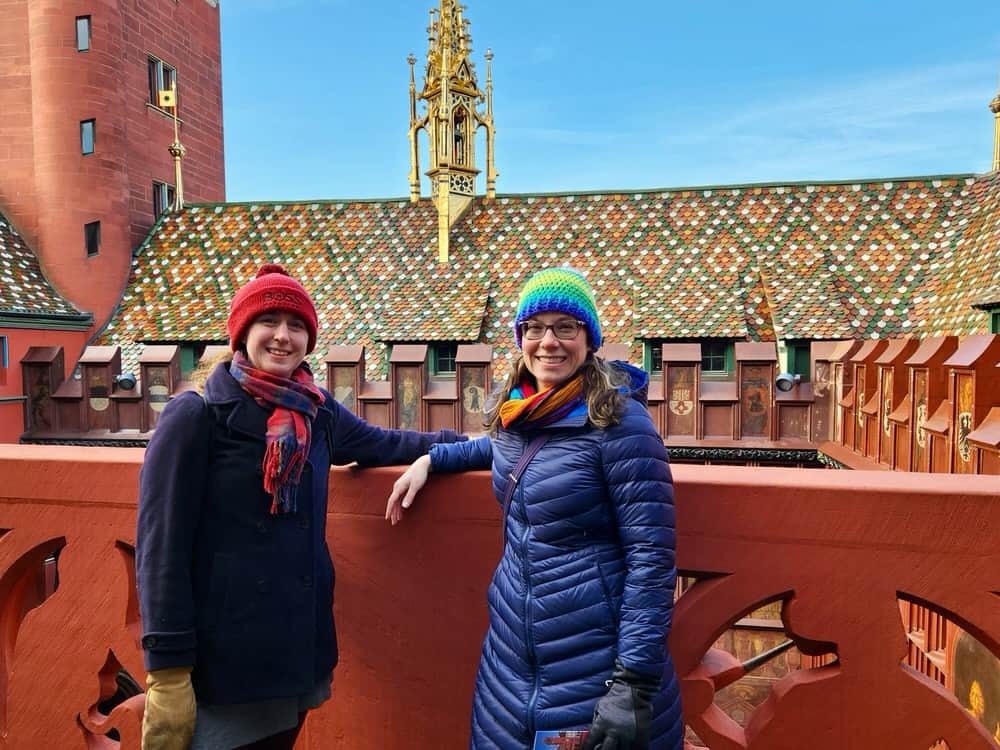 Two women pose on a roof top walkway at the Basel Town Hall