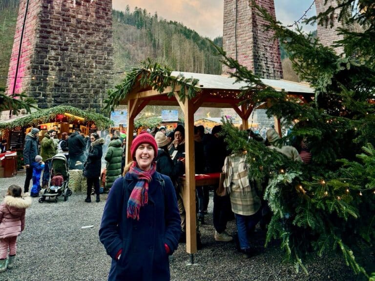 Woman in winter wear stands in a German Christmas Market