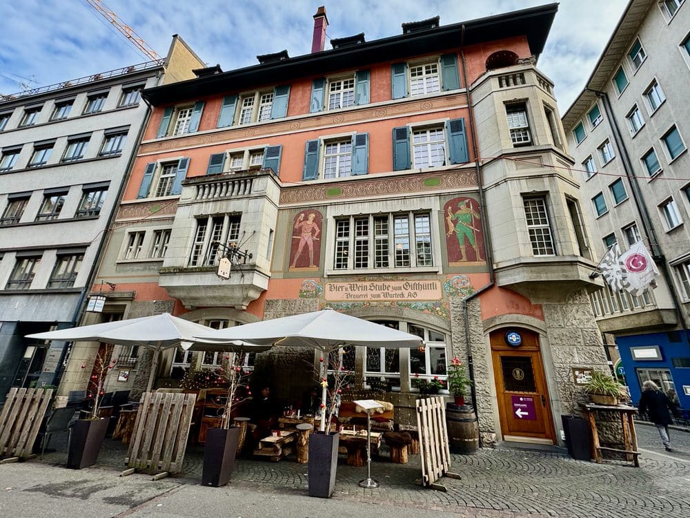 A historic red Swiss restaurant building with tents and Christmas decorations outside.