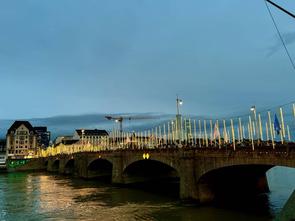 Christmas lights hanging on Mittlere Brücke across the Rhine River in Basel, Switzerland at dusk