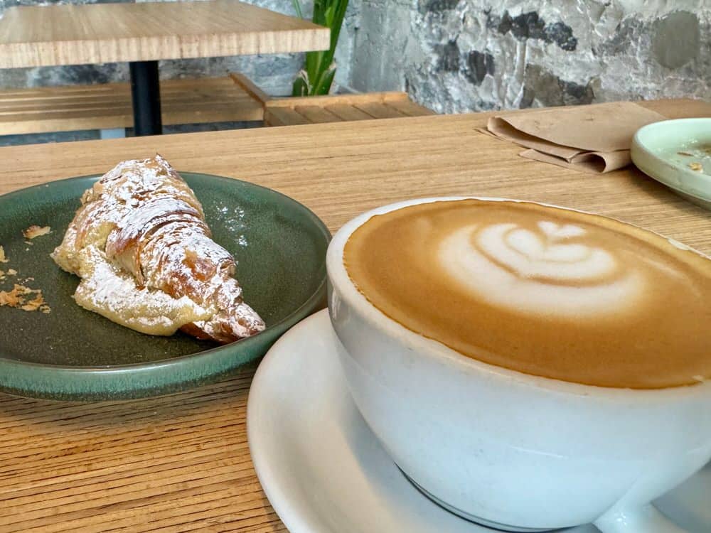A pastry and coffee drink with latte art sit on a cafe table in Ottawa Ontario