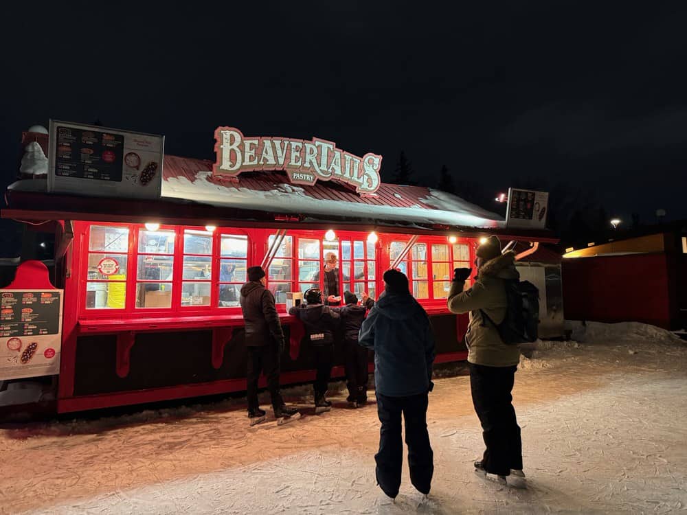 Skaters on the Rideau Canal Skateway in Ottawa wait to order at a Beavertail pastry stand