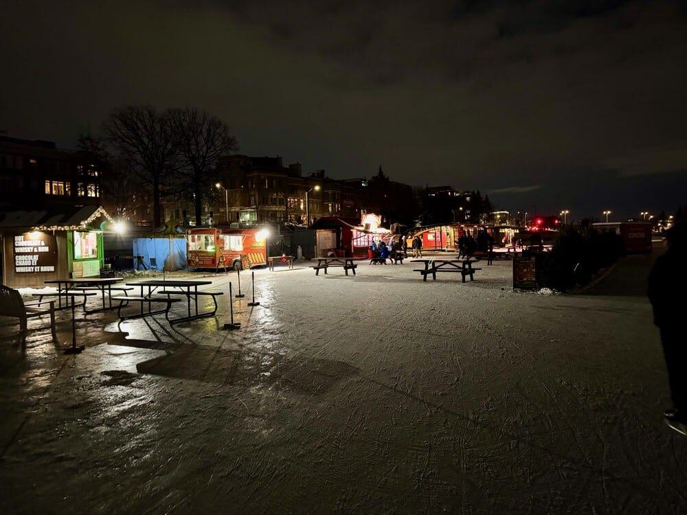 Food vendors, picnic tables, and small Christmas trees on the ice at Rideau Canal Skateway rest area