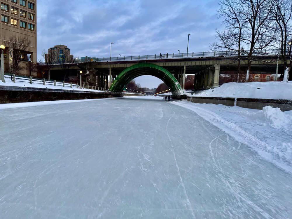 The frozen Rideau Canal passes through a bridge in downtown Ottawa