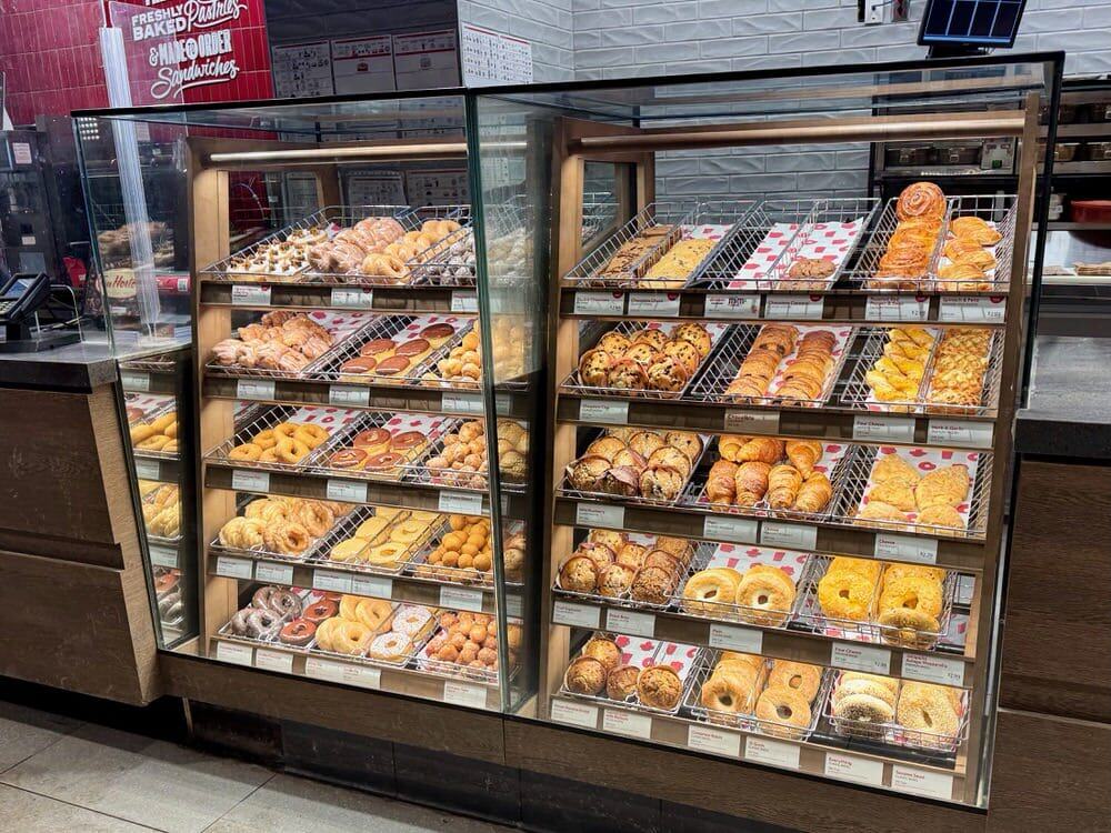 Bakery case filled with donuts, bagels, and croissants at Tim Hortons coffee shop