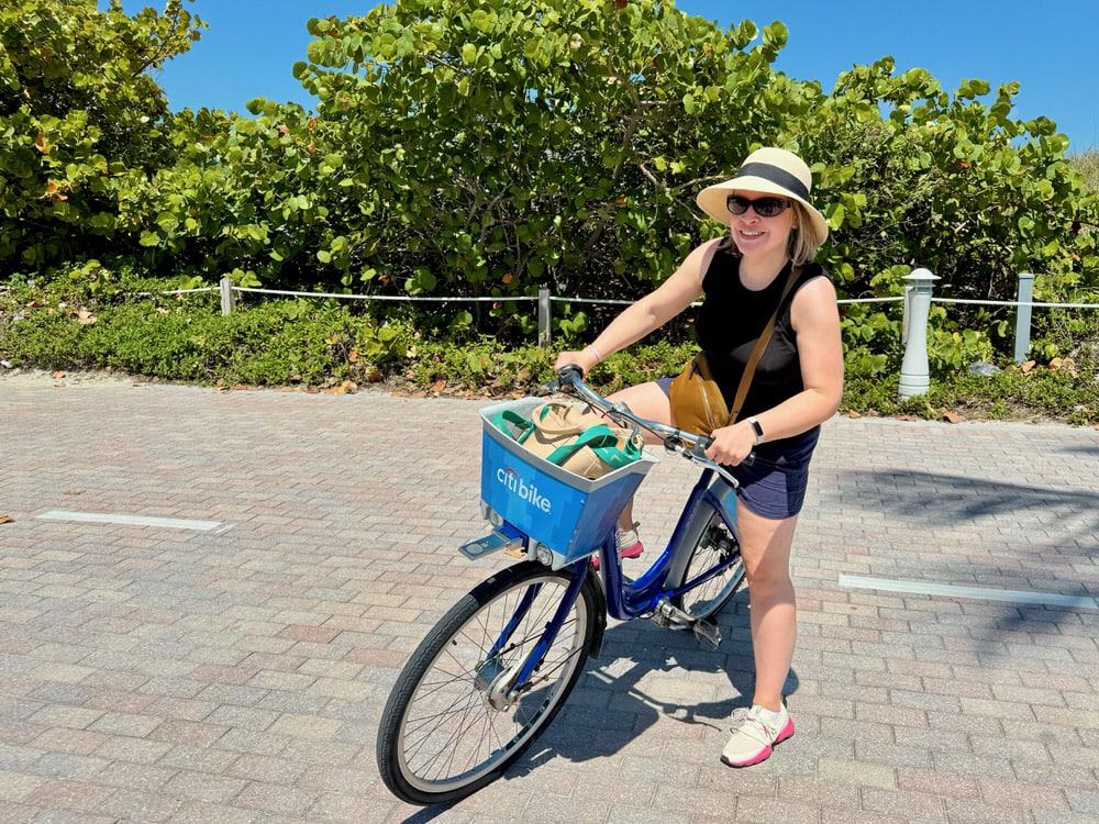 Woman gets onto a Citi Bike in South Pointe Park Miami Beach on a sunny day