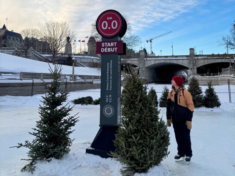 Woman stands at the start of the Rideau Canal Skateway in downtown Ottawa