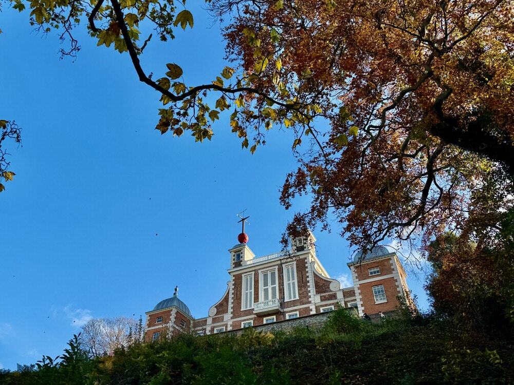 The roofline of the Royal Observatory in Greenwich London as seen through autumn leaves