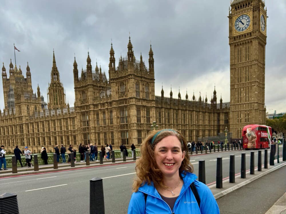 Woman stands in front of the UK Houses of Parliament in Westminster London