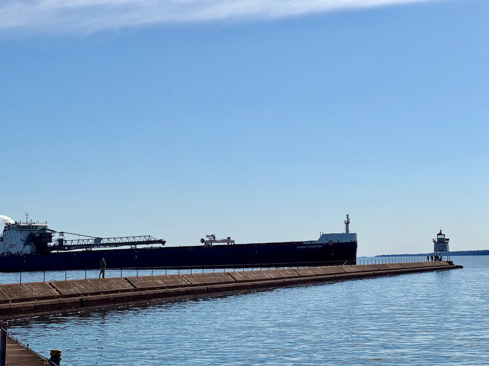 An ore ship passes by the Two Harbors lighthouse on its way into the docks
