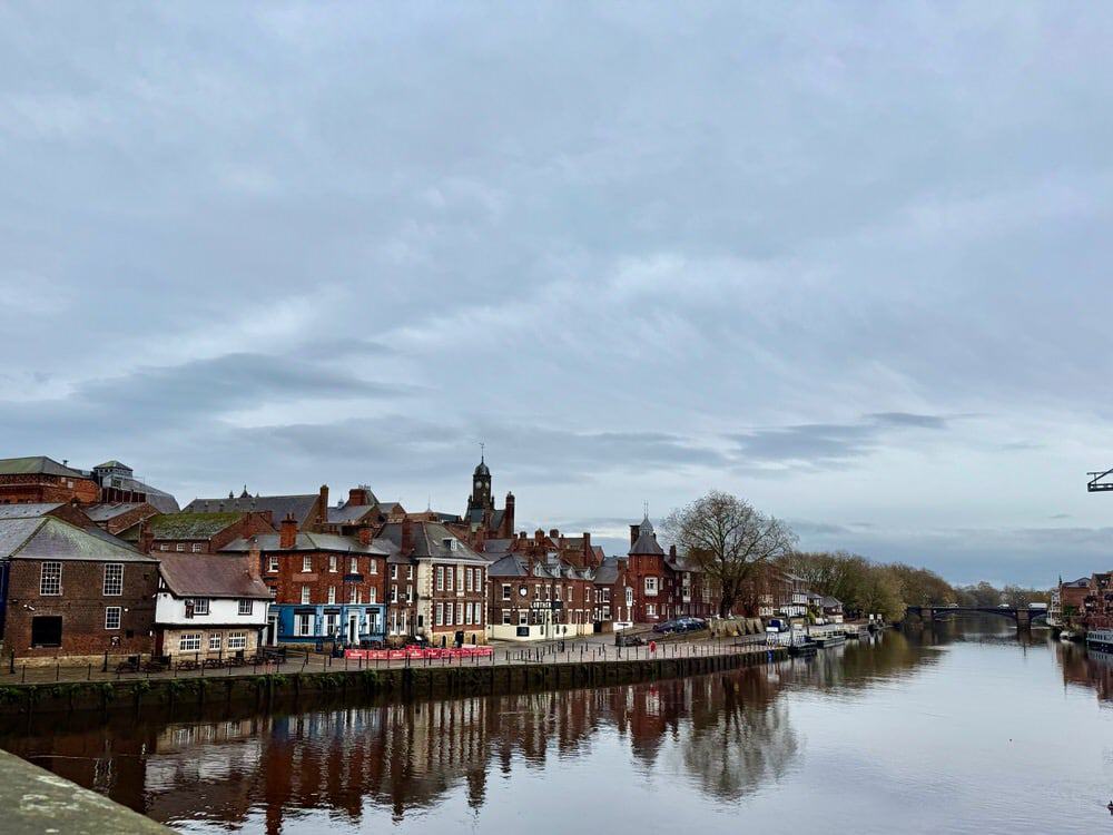 A wide river flows past traditional English frame buildings in York England