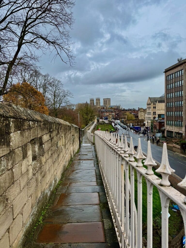 View looking down the top of York City Walls toward the City Centre and York Minster on an overcast day
