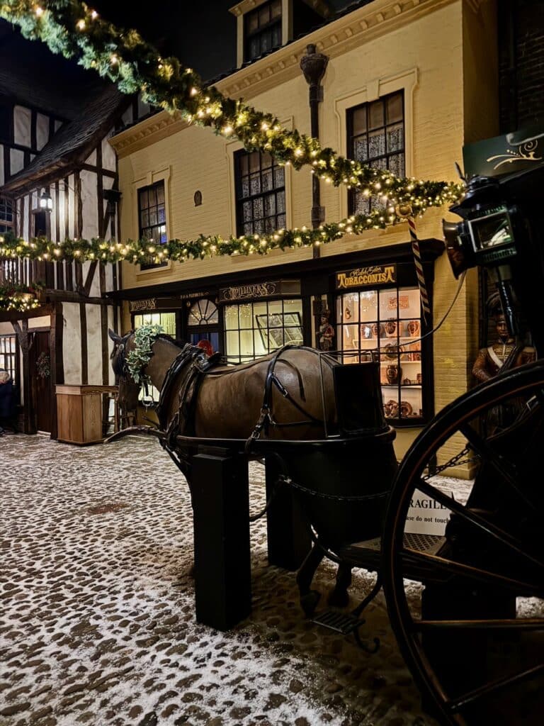 A lifesize horse and buggy stands in a museum street scene of Victorian England.