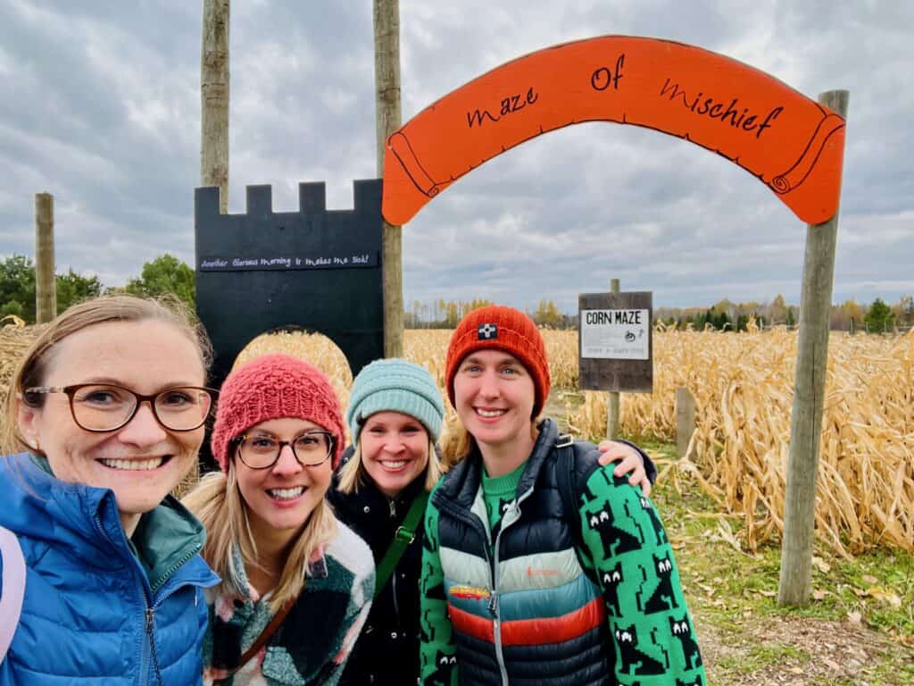 Women in front of the entrance to a corn maze