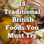 A breakfast plate of traditional British breakfast items including eggs, sausage, toast, bacon rashers, and baked beans. Text overlay reads "18 Traditional British Foods You Must Try."